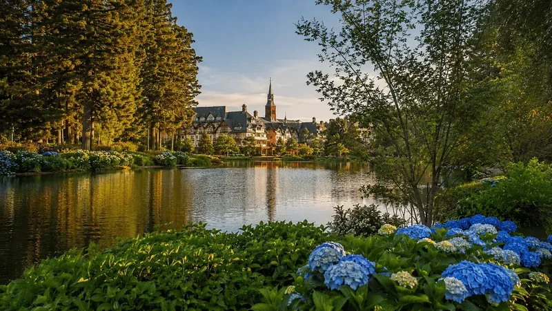 Lago e casario de Gramado ao entardecer, com hortênsias em primeiro plano